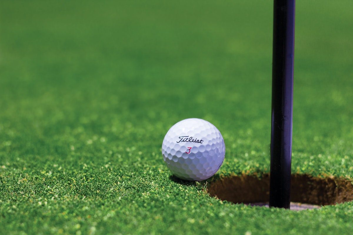 a golf ball on course on edge of hole