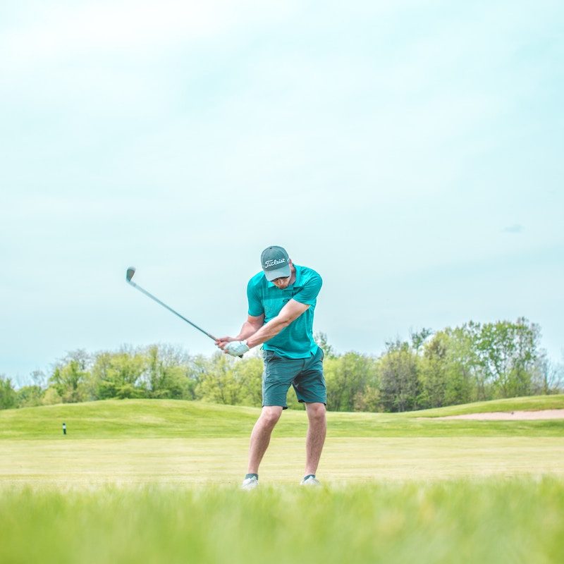 a person swinging golf club