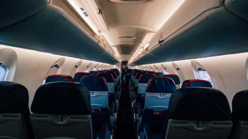 The inside of a plane with all of the seats empty.