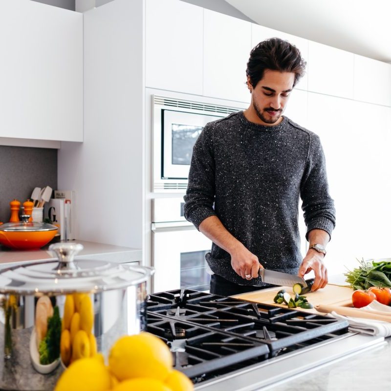 A person in the kitchen preparing the food to cook.