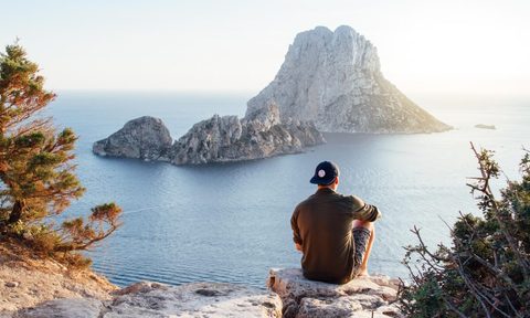 least and most expensive travel destinations person overlooking cliff water jpg