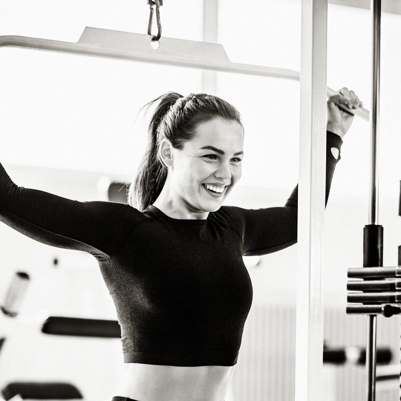 Woman doing behind-the-neck pulldowns.