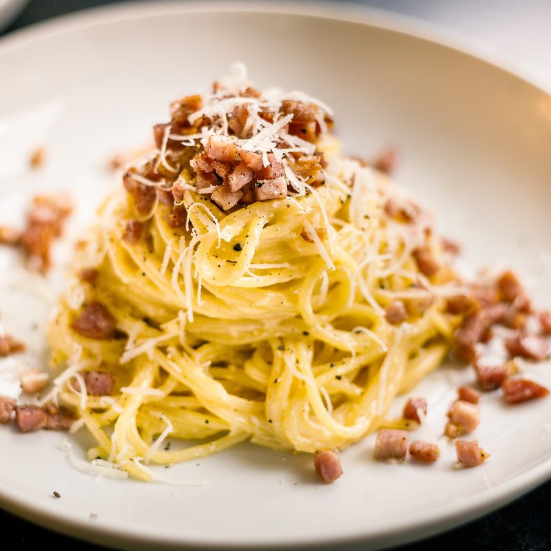 Pasta on white plate with cheese on top