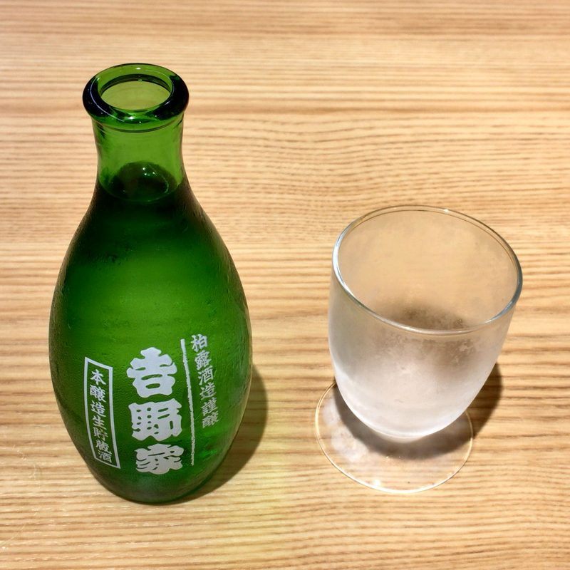 A sake set consisting of a green glass sake bottle and a short glass
