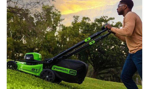 A man using a Greenworks lawn mower.