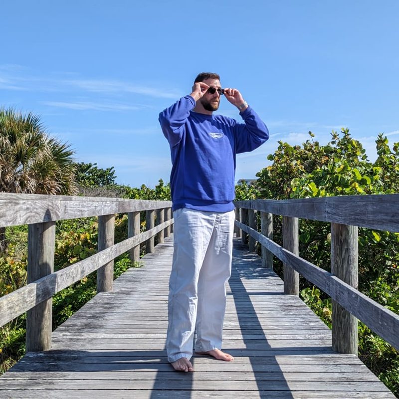 Man in Quicksilver Saturn Collection sweatshirt and pants on boardwalk