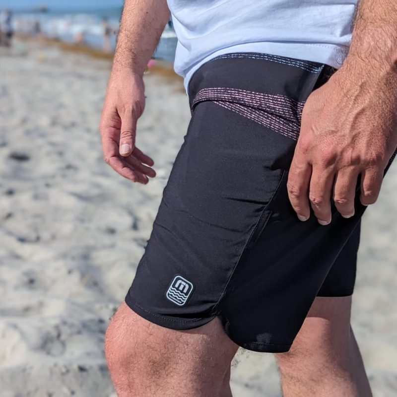 Man wearing Travis Mathew board shorts on the beach