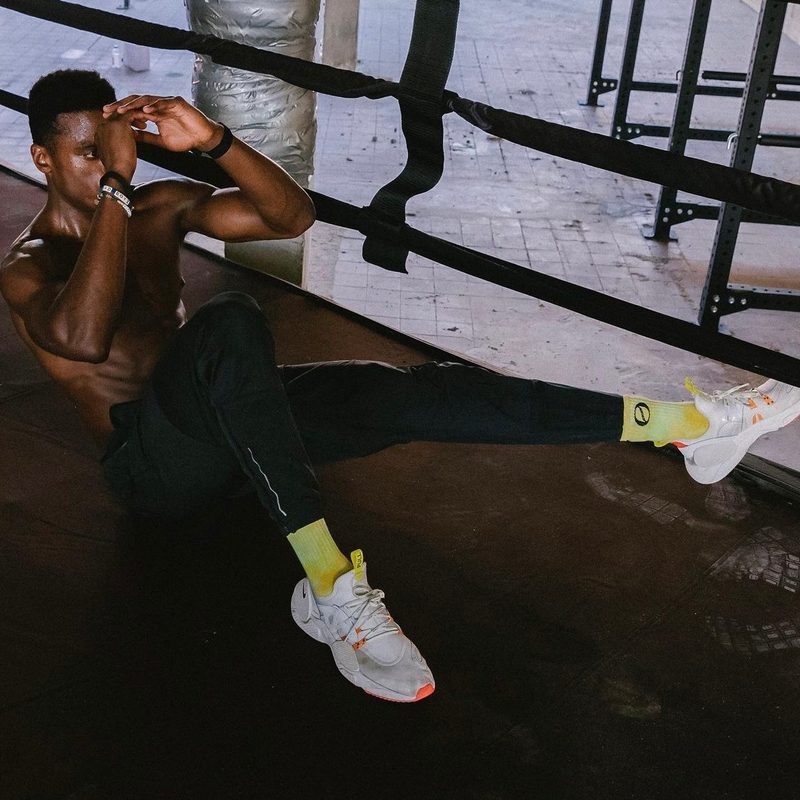 Nike trainer Joe Holder performing an ab crunch in a boxing ring.