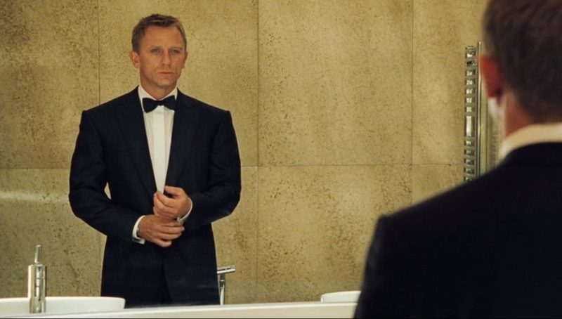 James Bond in a black dinner jacket looking in a mirror in Casino Royale