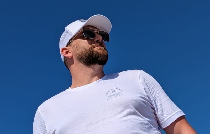 Man in Travis Mathew tee and hat