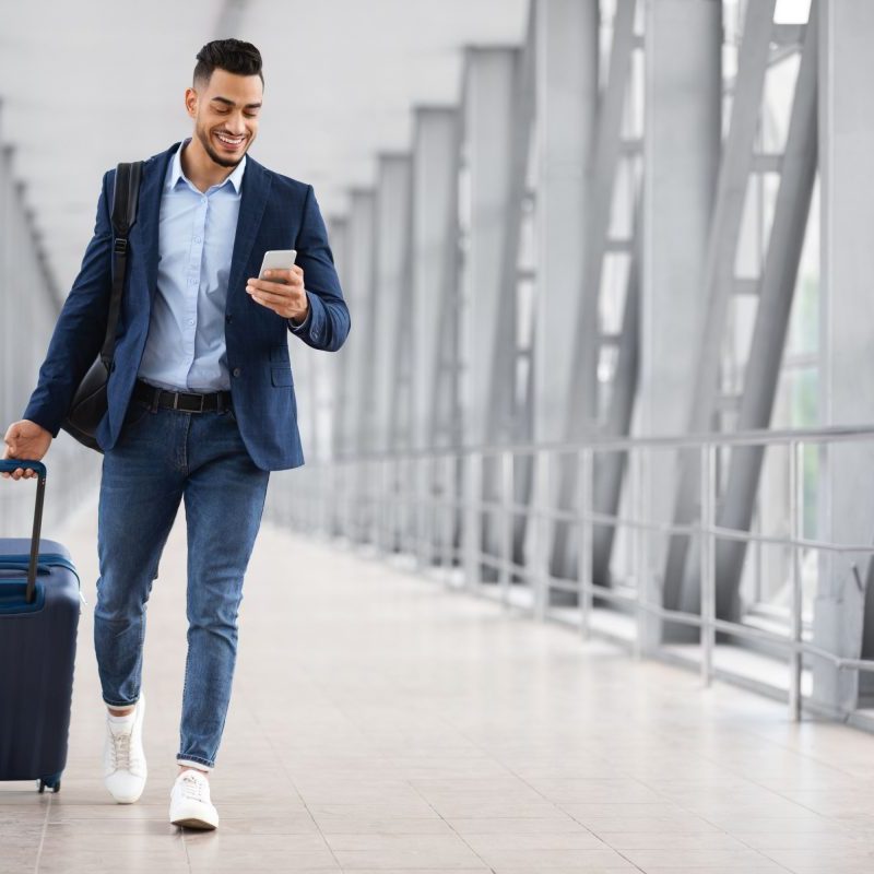 Man walking through airport with luggage.