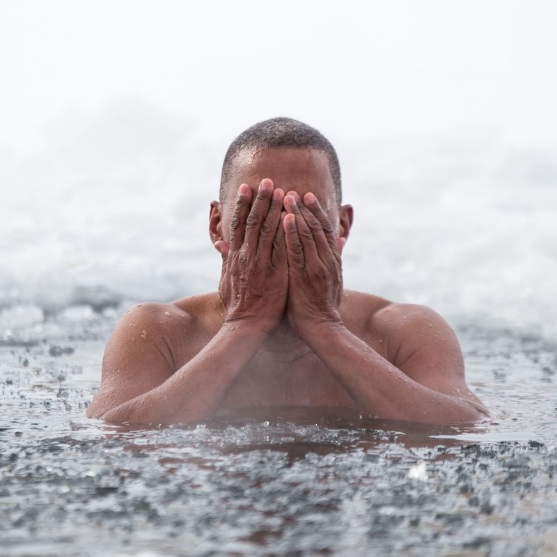 man swimming in ice