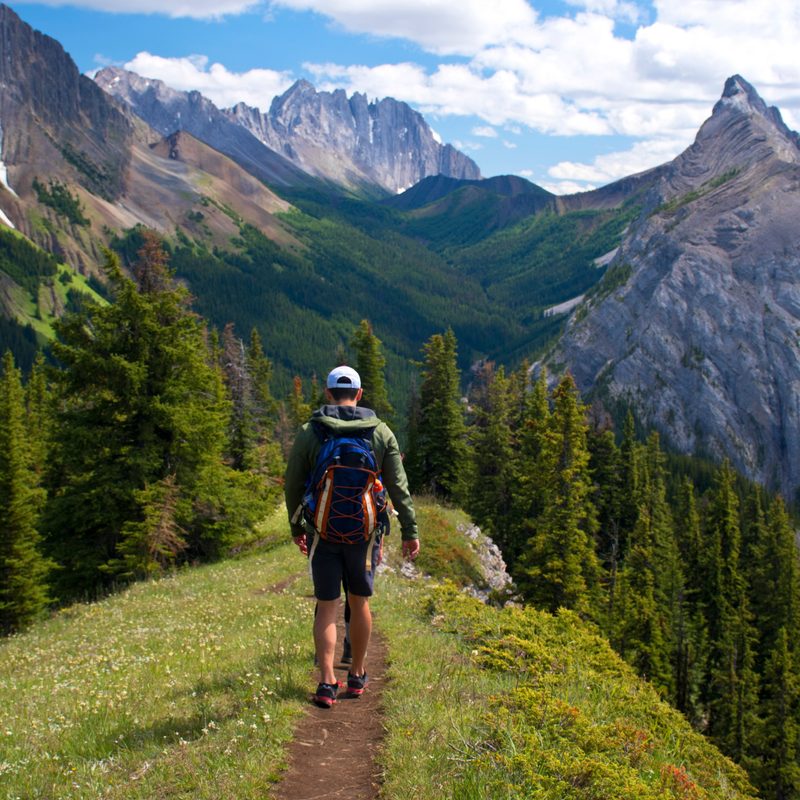 Young man hiking through the mountains.