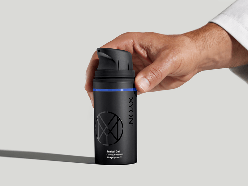 Xyon topical gel held by a doctor during product demo.