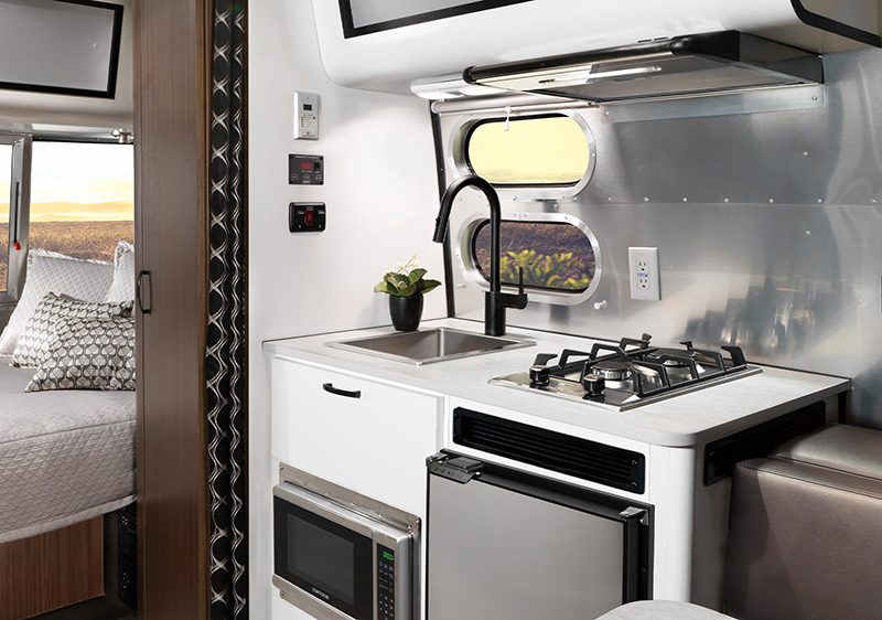 Kitchen and bedroom setup inside the Airstream Caravel 16RB travel trailer.