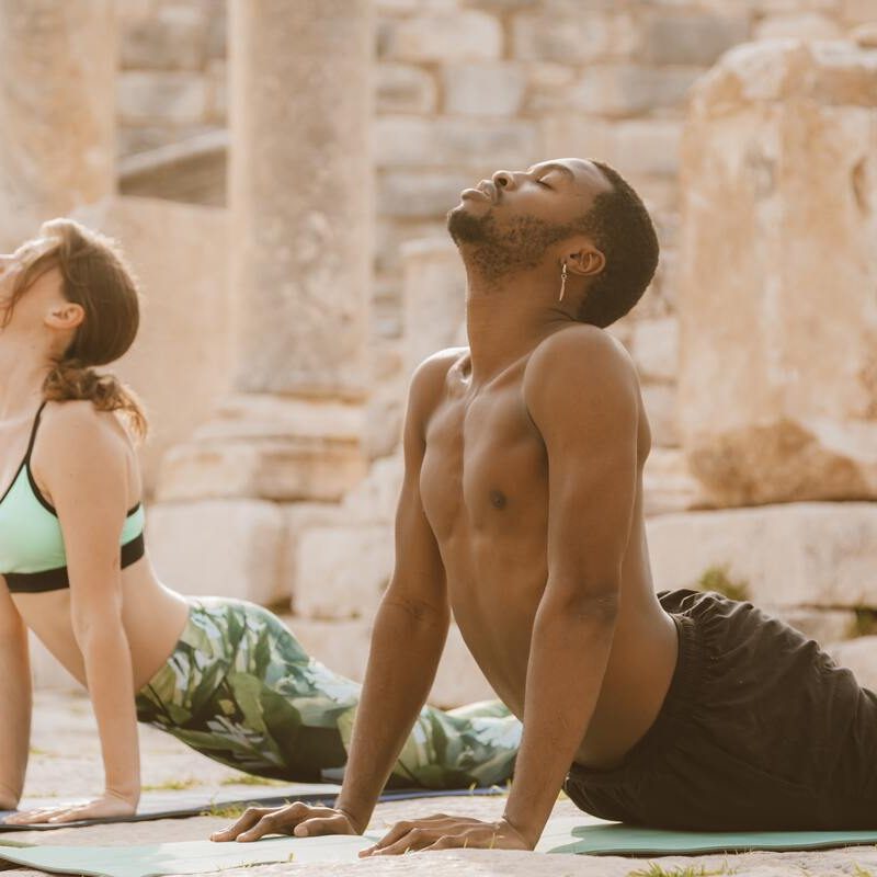 Man and woman doing upward dog.