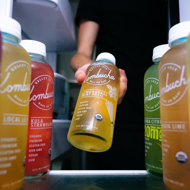 Man grabbing kombucha from fridge.