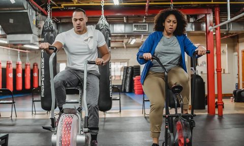 Man and woman on stationary bikes