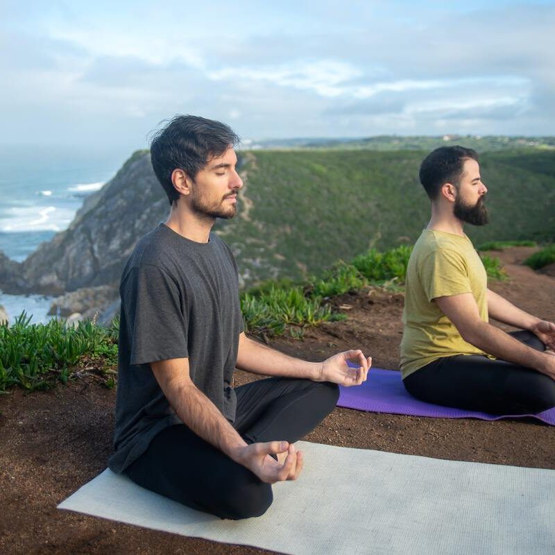 Two men meditating outdoors.