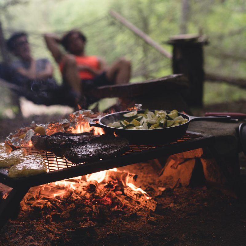 Food cooking over a fire at a campsite
