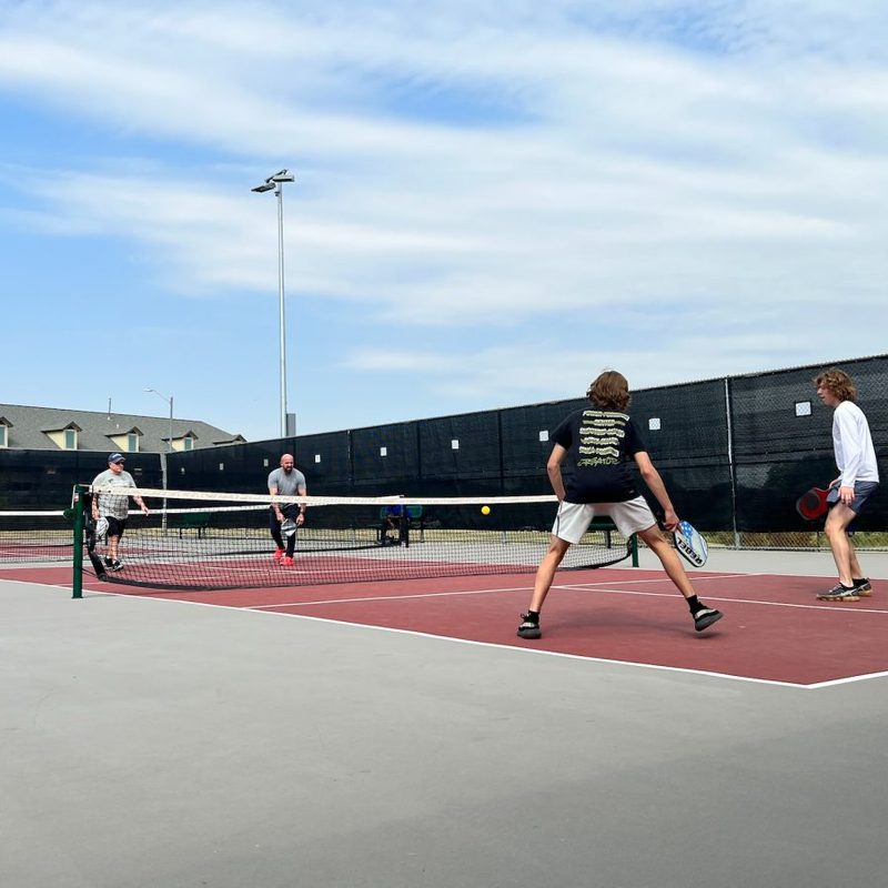 A group of people playing a game of pickleball.