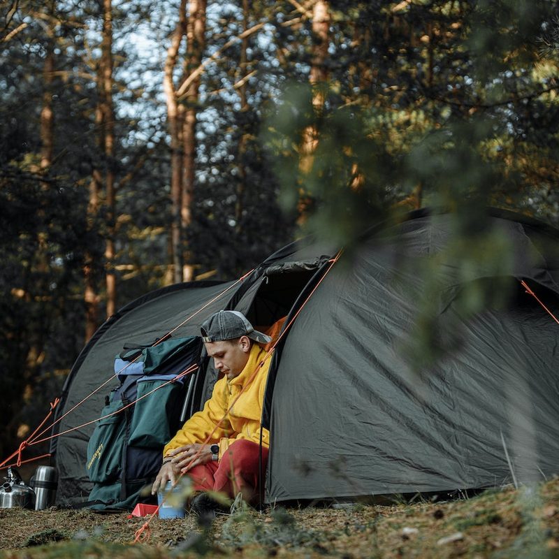 A man sitting in the doorway to his tent.
