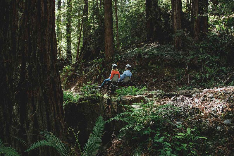 Couple taking an electric rail bike tour along the Redwood Route in Pudding Creek, California.