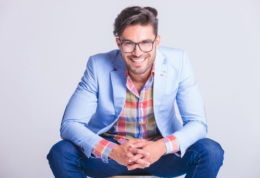 Man in light blue sport coat kneeling