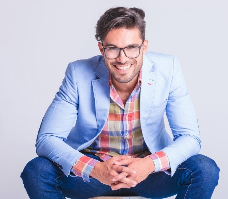 Man in light blue sport coat kneeling