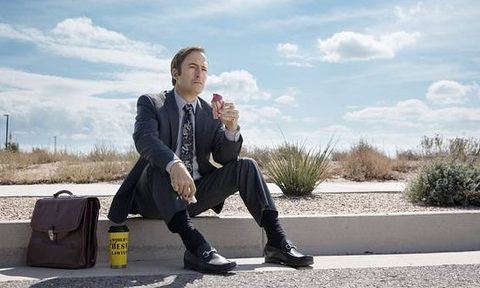 Bob Odenkirk sitting on the curb in loafers
