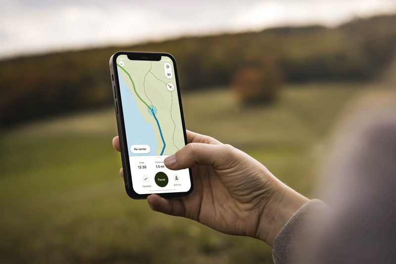 A person holding a phone with the AllTrails maps open.