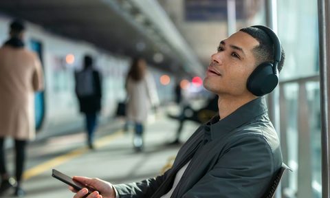 Listening to music in an airport with wireless headphones.