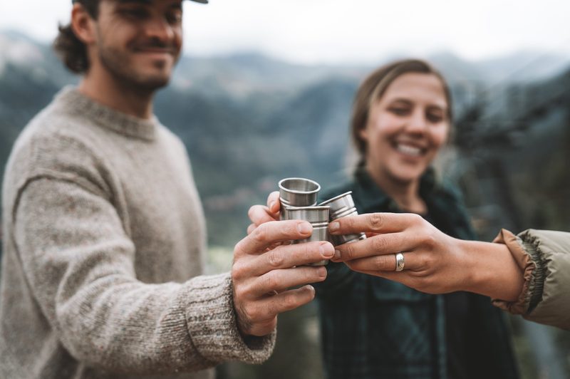 A couple of people enjoy some TINCUP whiskey up in the mountains.