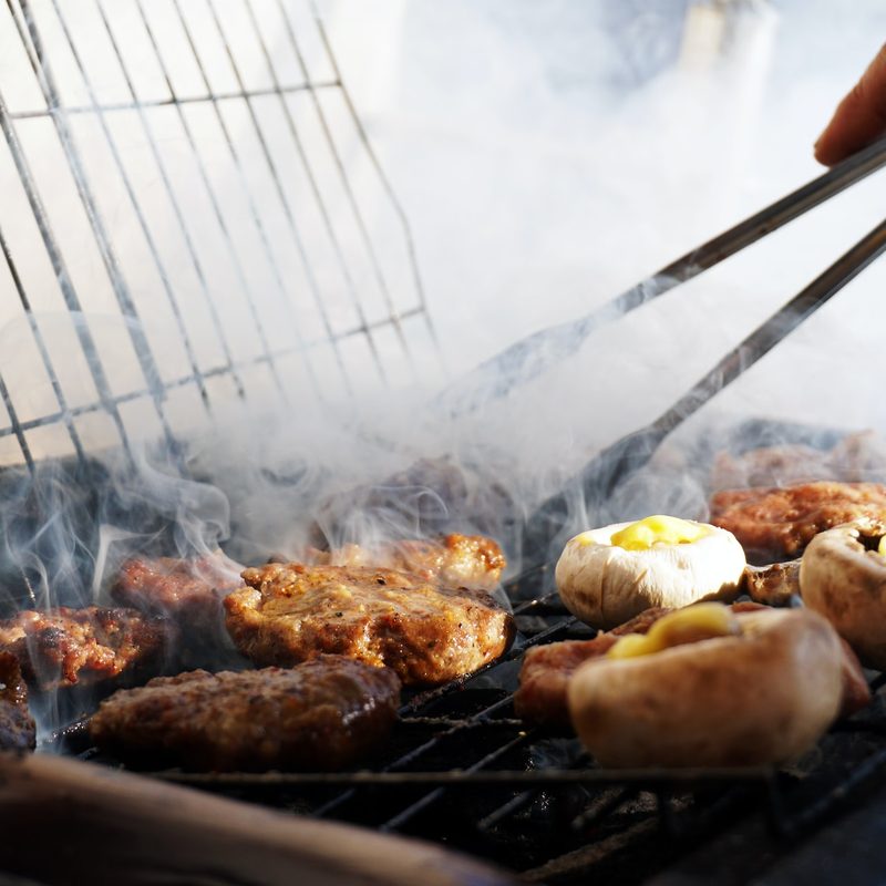 Person grilling with tongs