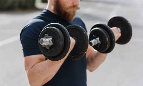 A bearded man doing a biceps curl