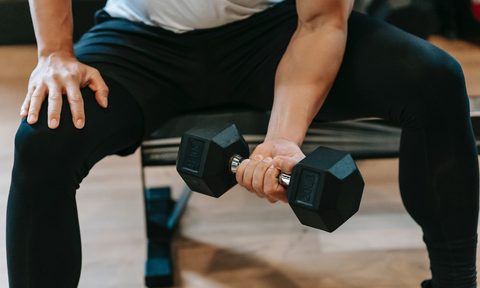 a man doing a bicep curl concentration close up dumbbell