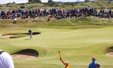 A crowd watching a golfer take a shot.