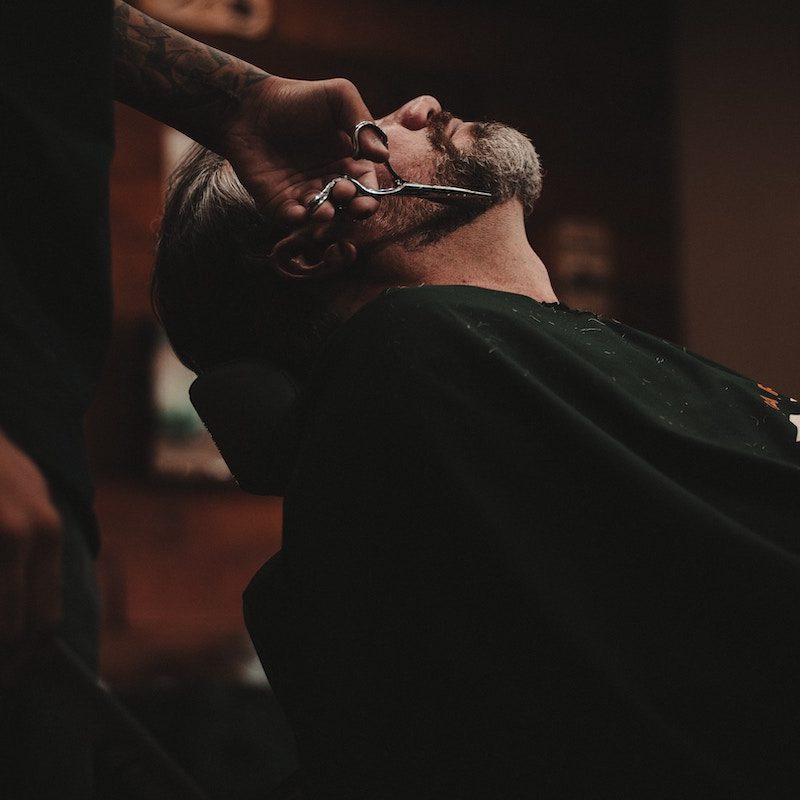 a dark photo of a man in a barber shop