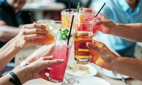 Hands toasting with cocktails