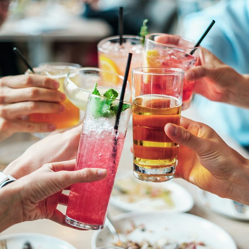 Hands toasting with cocktails