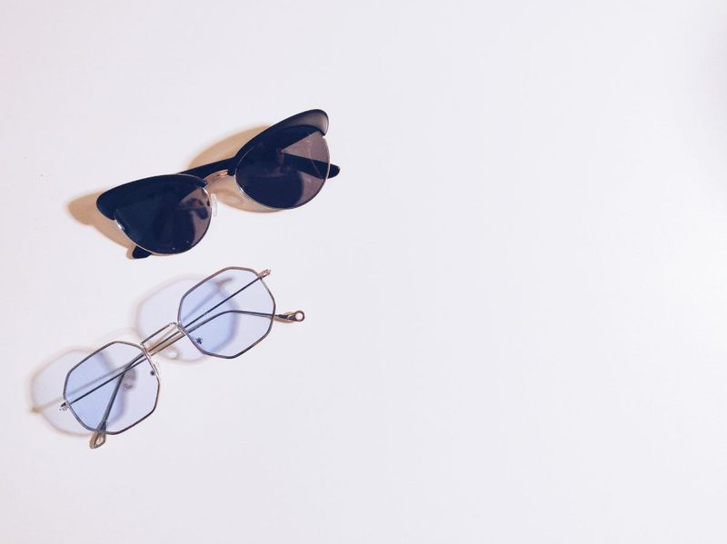 A pair of sunglasses and eyeglasses on a table.