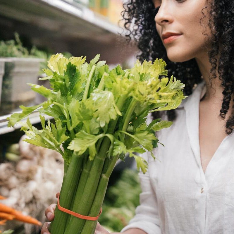 Woman holding celery in grocery store
