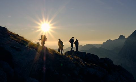 A silhouette of some hikers against the sun