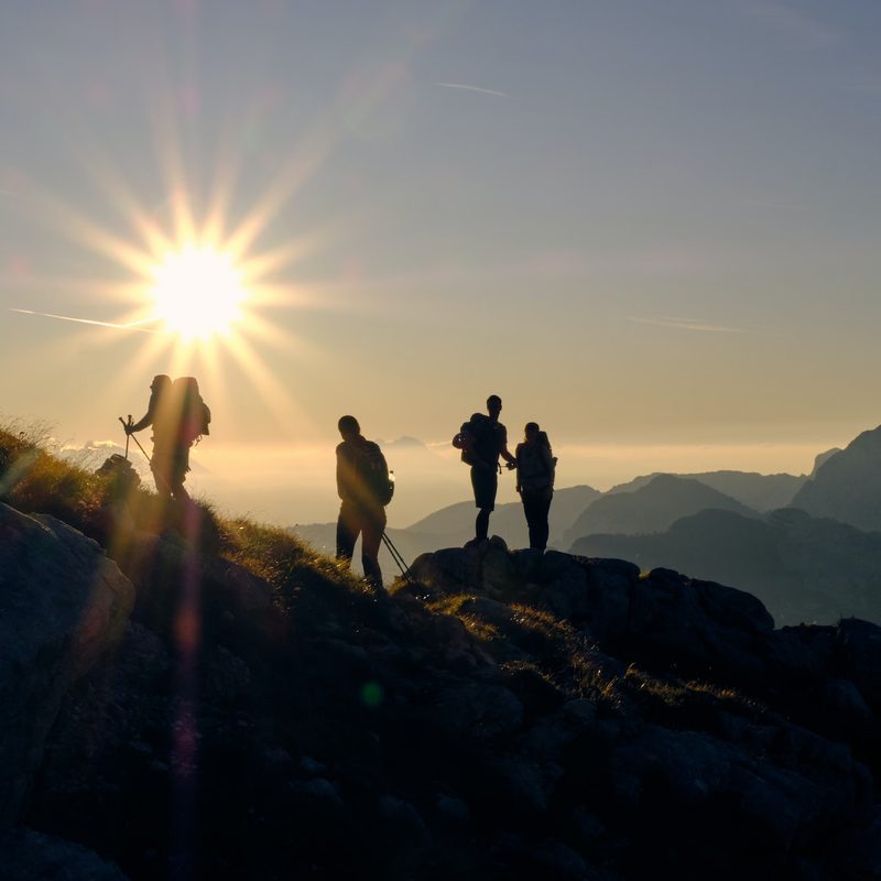 A silhouette of some hikers against the sun