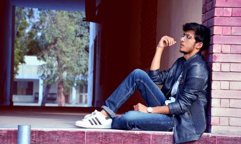 Man sitting wearing cuffed jeans