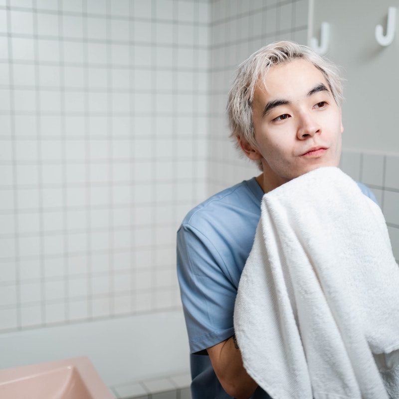 Young man drying his face