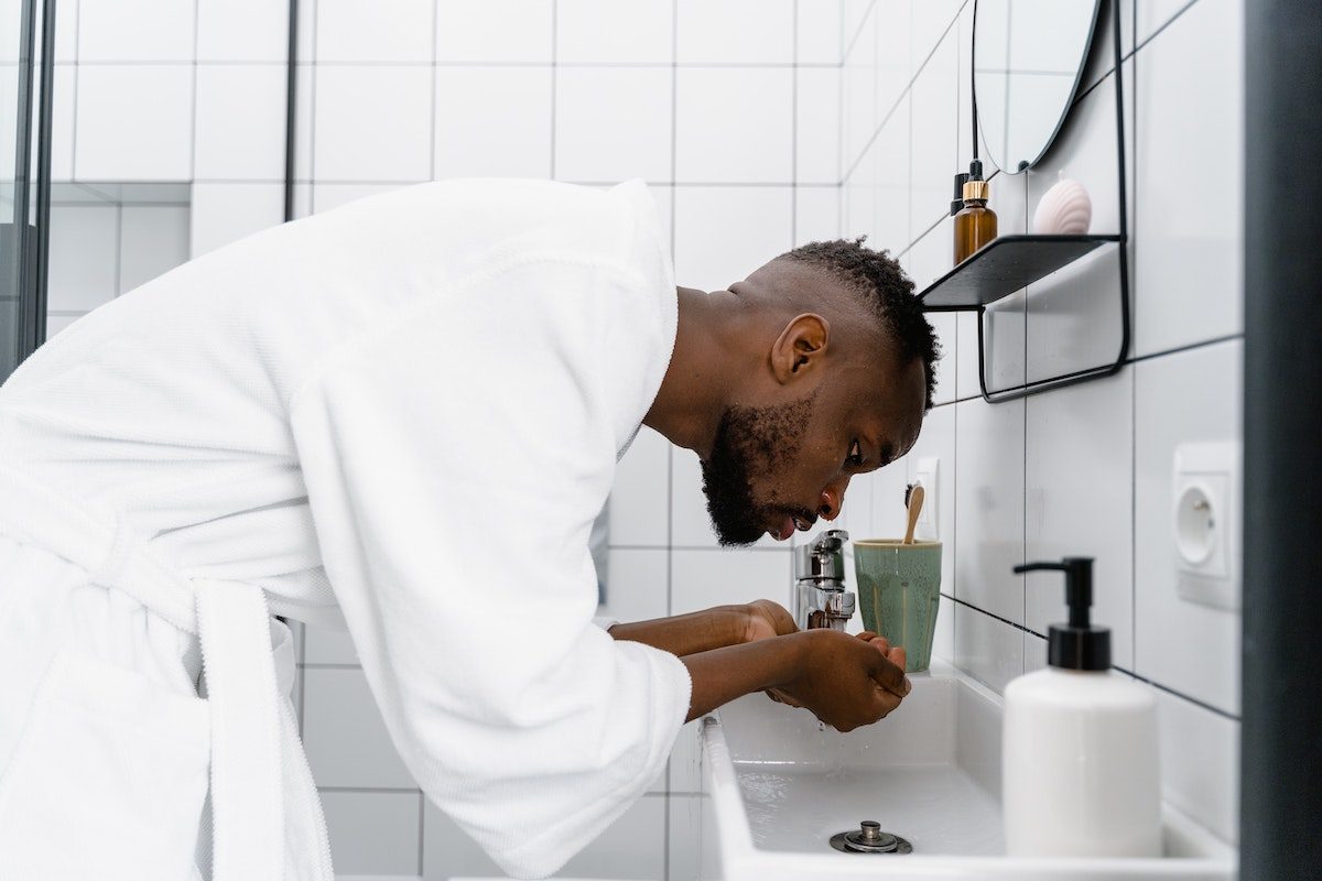 a man in a white robe washing face