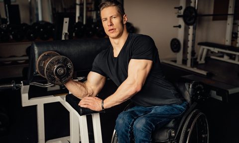 a man in a wheelchair performing a biceps curl