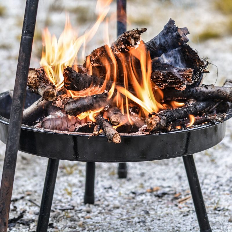 A fire burns away on a camping fire pit