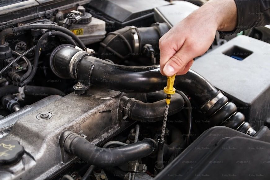 Checking oil under the hood of a vehicle before a trip.
